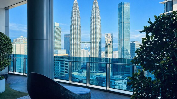 A balcony with a view of the Petronas Towers and other modern buildings. - Eaton Residences KLCC by Luna (Kuala Lumpur)