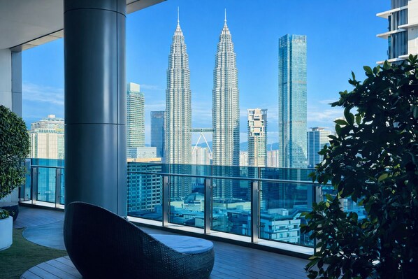 A balcony with a view of the Petronas Towers and other modern buildings. - Eaton Residences KLCC by Luna (Kuala Lumpur)
