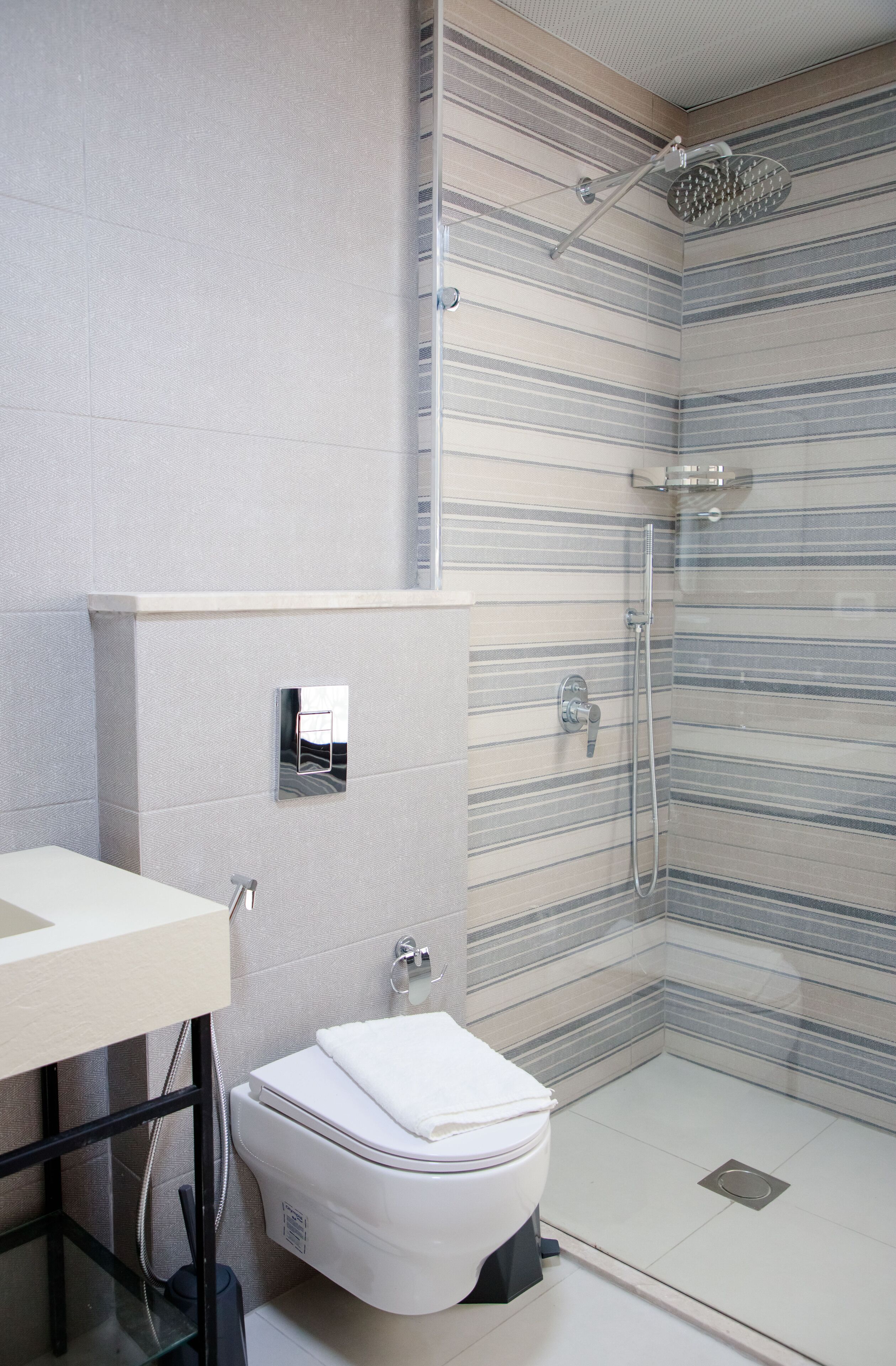 A modern bathroom with a shower, toilet, and sink.