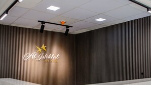 A reception desk with a modern design, featuring a logo and a star emblem. - Al-Istiklal Suites (Ramallah)