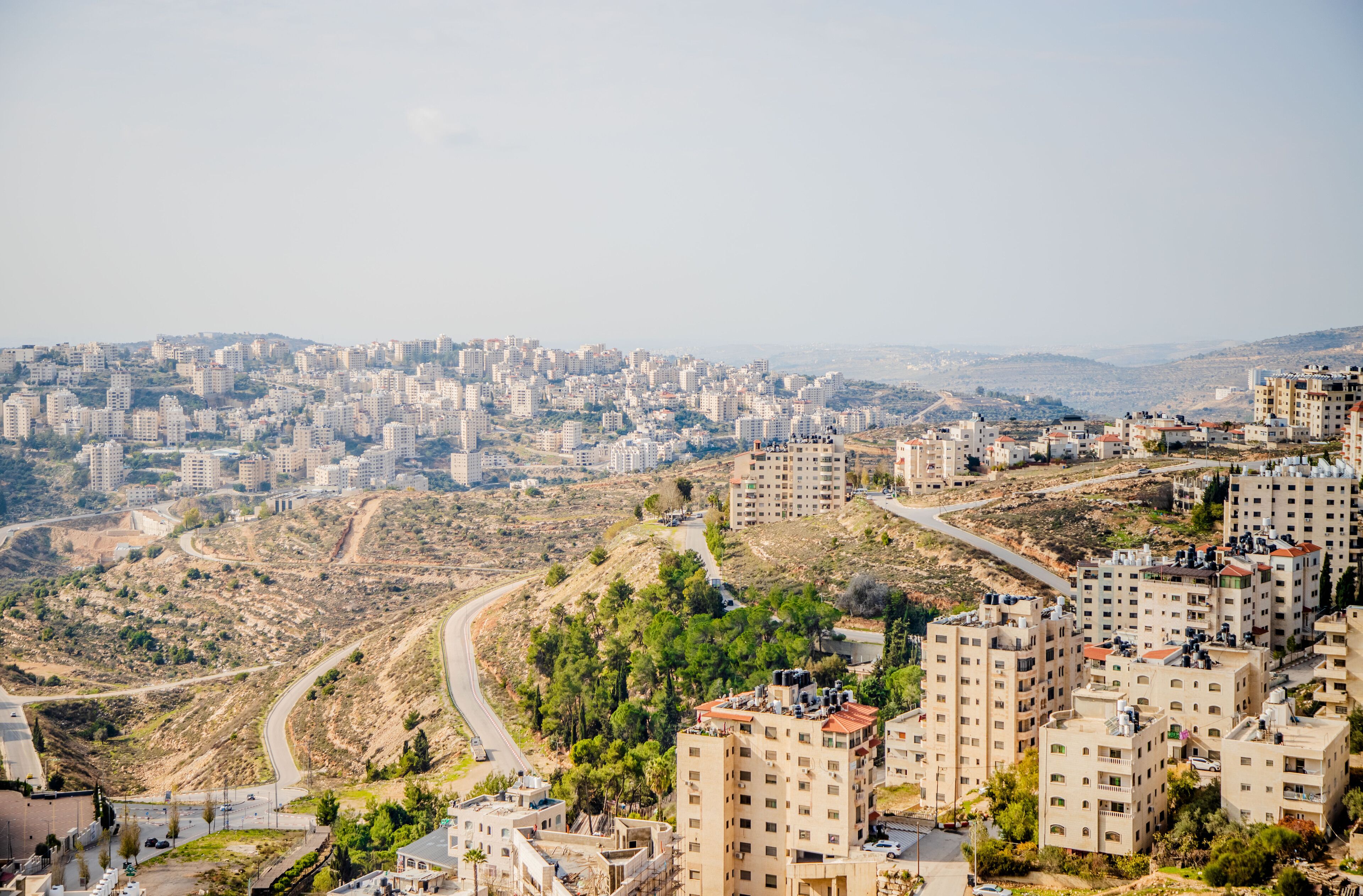 A high-rise residential area with multiple apartment buildings, winding roads, and hilly terrain.