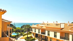 A coastal hotel with multiple balconies, a swimming pool, and a view of the sea. - Cozy Apartment w/ Pool in Albufeira (Albufeira)