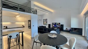 Un espace de vie moderne comprenant une cuisine, un coin repas et un espace dédié aux loisirs.