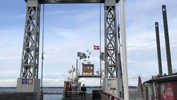 Entrada de un muelle con un letrero que dice "Boga", una bandera y un pequeño edificio con un letrero.