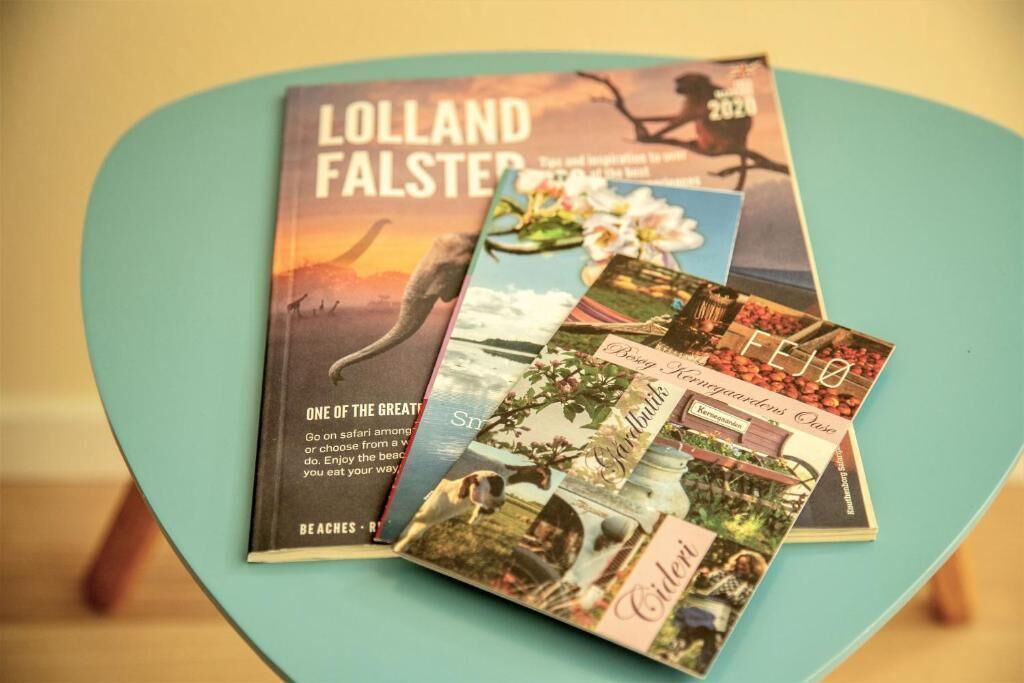 A teal chair with a stack of travel brochures on it.