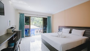 A hotel room with a large bed, a desk, a TV, and a balcony with curtains. - O'shop Residence Patong Beach (Patong)