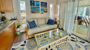 A cozy living area with a sofa, coffee table, and artwork on the walls.