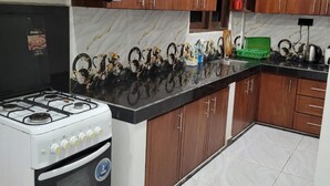 A kitchen with wooden cabinets, a gas stove, and a marble backsplash. - New 5 bed Room Villa (Piliyandala)