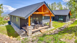 A modern house with a covered porch, stone foundation, and a view of the surrounding landscape. - New Modern Mountain Retreat with Level 2 EV Charger (Granby)