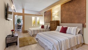 Une chambre avec deux lits, une commode en bois, une petite table avec un vase et un miroir au mur.