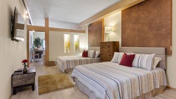 A bedroom with two beds, a wooden dresser, a small table with a vase, and a mirror on the wall.