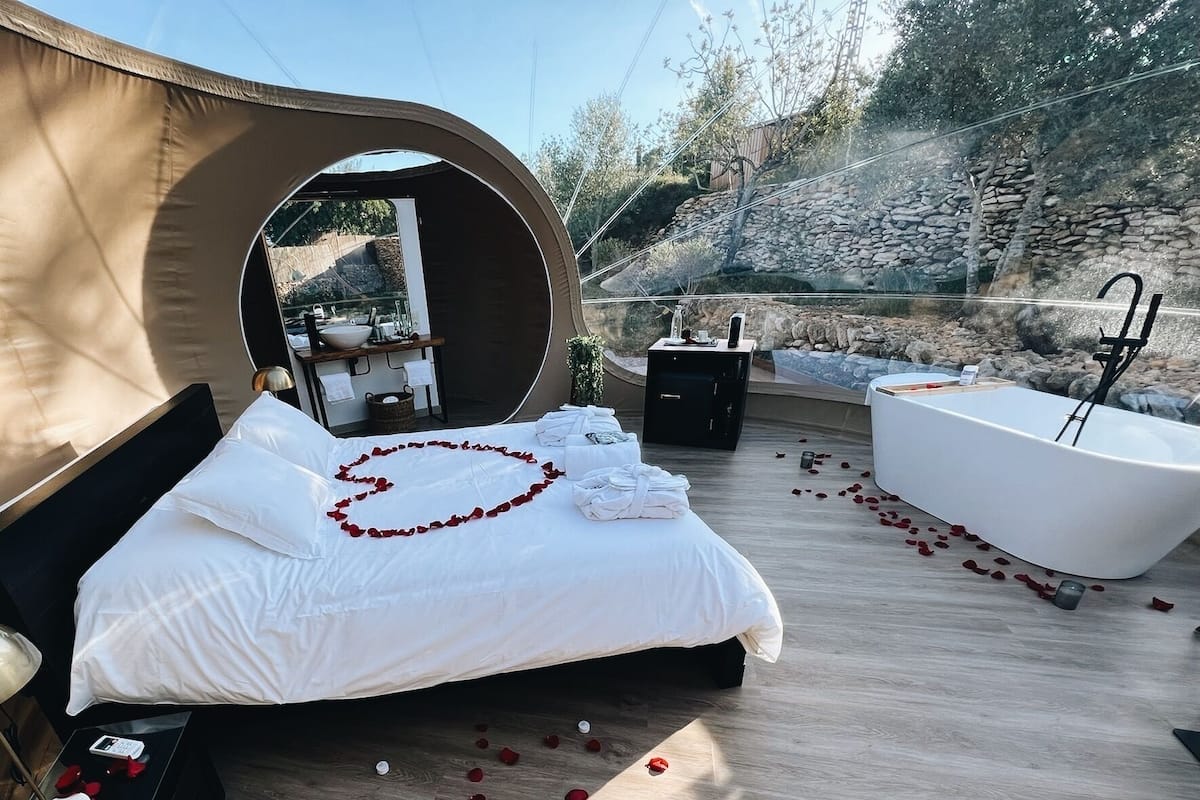 Une chambre à coucher avec un lit, une baignoire et une fenêtre ronde.
