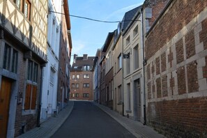 Una calle estrecha bordeada de edificios tradicionales, con una combinación de fachadas de ladrillo y entramado de madera.