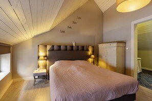 Un dormitorio con una cama grande, una mesita de noche, un armario y una pared con palabras inspiradoras.