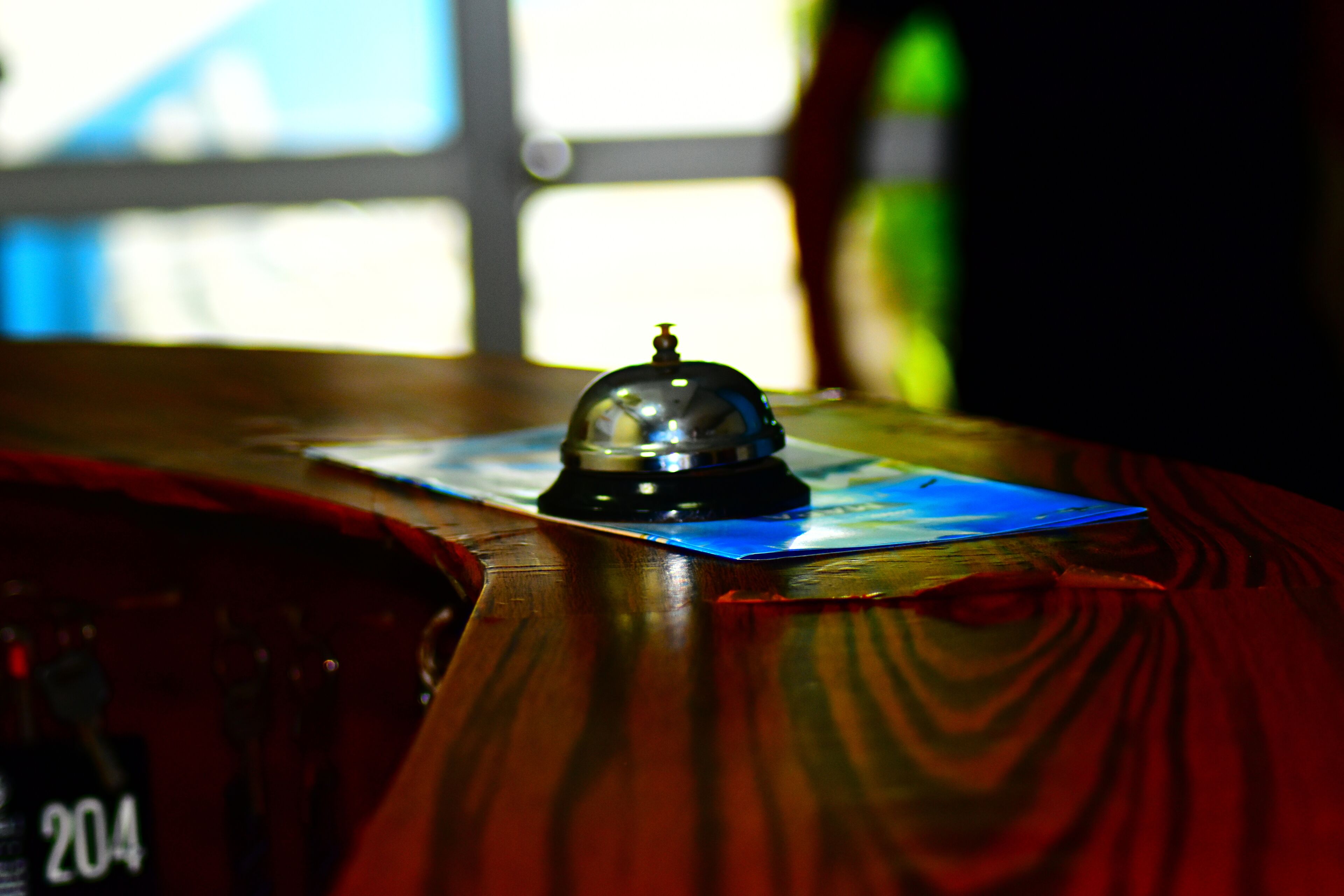 A wooden table with a bell, a blue card, and a number 204 visible.