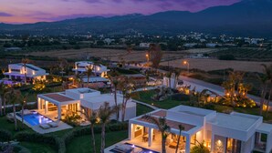 Una zona residenziale moderna con diverse case, una piscina e giardini curati.