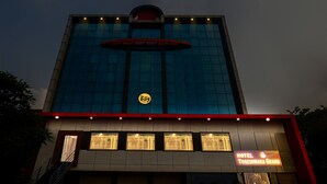 A hotel building with a modern glass facade, a prominent logo, and a sign indicating the name 'Hotel Yogeshwara Grand'. - Itsy Hotels Yogeshwara Grand (Hyderabad)
