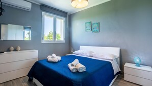 Une chambre moderne avec un grand lit, une table de chevet, une commode, un miroir et une fenêtre.