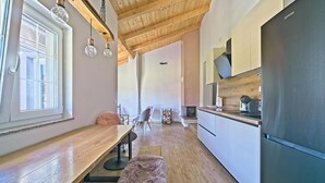 Una cocina moderna con vigas de madera, un ventanal grande y un comedor con banco y sillas.