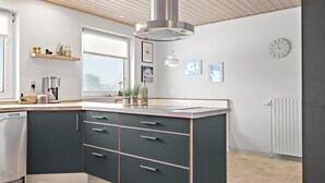 A modern kitchen with a central island, built-in appliances, and a large window. - 3 bedroom pet friendly home in Ulfborg (Ulfborg)