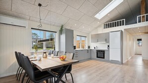 A modern kitchen with grey cabinets, a white refrigerator, and a built-in oven.