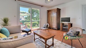 A spacious living room with a sofa, a wooden coffee table, and a TV stand.