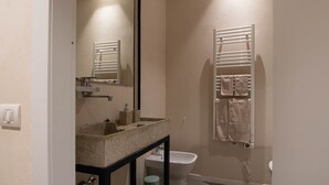 Un bagno con lavabo in granito, un WC bianco e un portasciugamani con asciugamani.