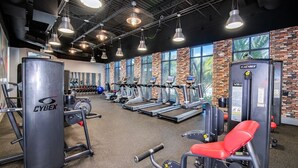 A gym with Cybex equipment, large windows, and a brick wall. - NEW! 2 Pools + Gym, Kids Water Playground, Near Disney {Chic Retreat} (Davenport)
