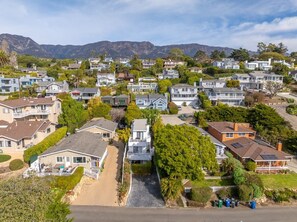 A residential area with houses, a central driveway, and mountains in the background.