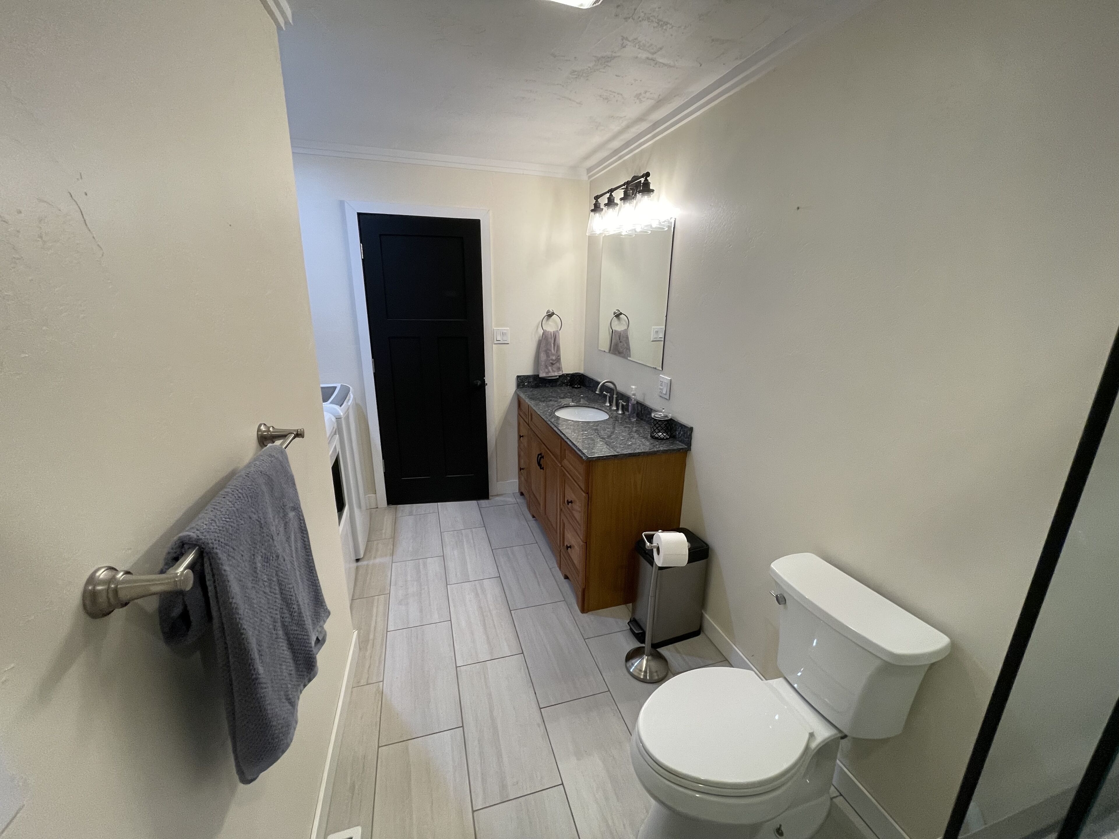 Et lille badeværelse med toilet, vask og spejl.