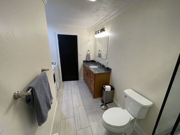 A compact bathroom with a toilet, sink, and mirror.