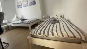 A bedroom with two beds, a desk, and a chair. - Alter Ziegelhof Vechta (Vechta)