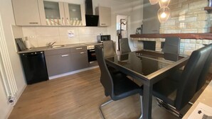 A modern kitchen with a dining area. - Alter Ziegelhof Vechta (Vechta)