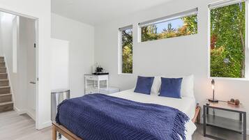 Relax in a serene bedroom with a large bed, bedside table, and comfortable seating area.