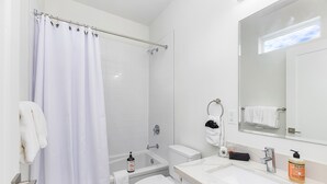 A modern bathroom with a bathtub, toilet, and sink.