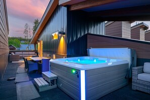 Un área de hidromasaje al aire libre con asientos y una terraza de madera.