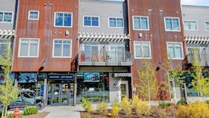 A modern multi-story building with a storefront on the ground floor, featuring a sign for a rafting and off-road equipment rental service.