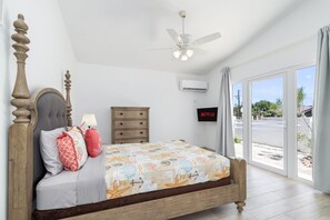 A bedroom with a bed, a dresser, a ceiling fan, an air conditioning unit, and a TV displaying 'NETFLIX'. - 4BR4BA w/ Private Pool ~ Walking distance to Ritz (Noord)