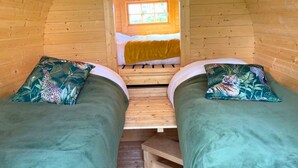 Een knus chalet met twee bedden, een raam en een houten inrichting.