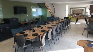 Un comedor con una mesa larga, sillas y una escalera.