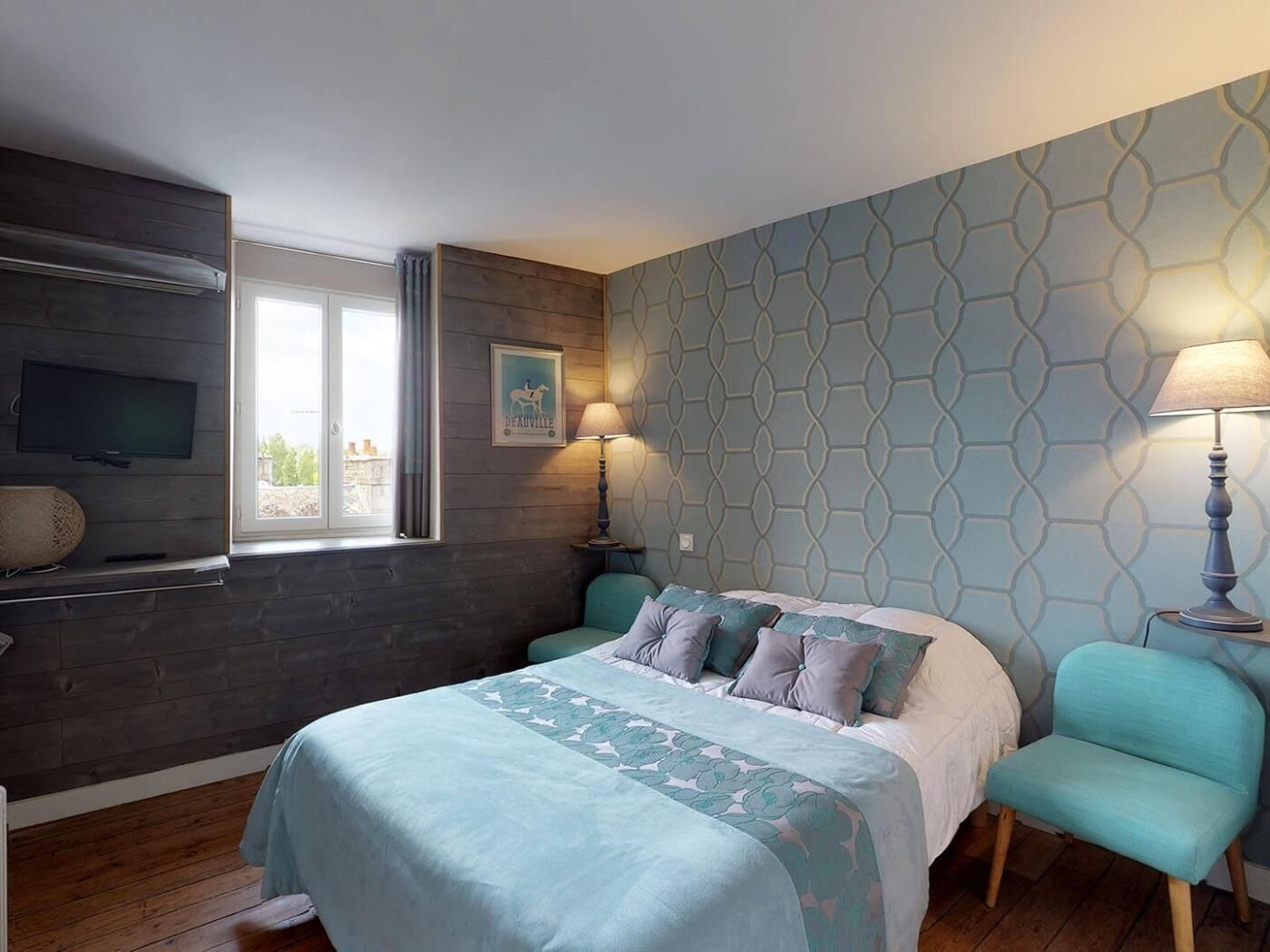 Une chambre à coucher avec un lit, deux lampes de chevet, une télévision et une fenêtre.