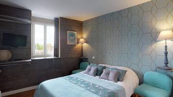 Une chambre à coucher avec un lit, deux lampes de chevet, une télévision et une fenêtre.