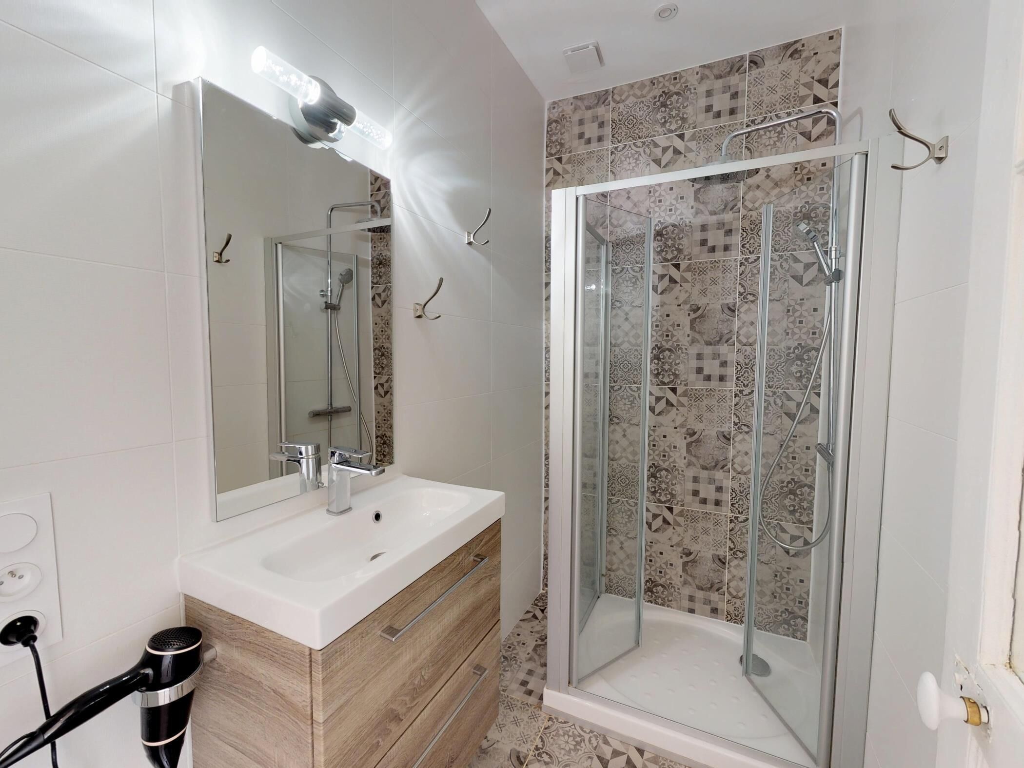 A bathroom with a shower, a sink, and a mirror.