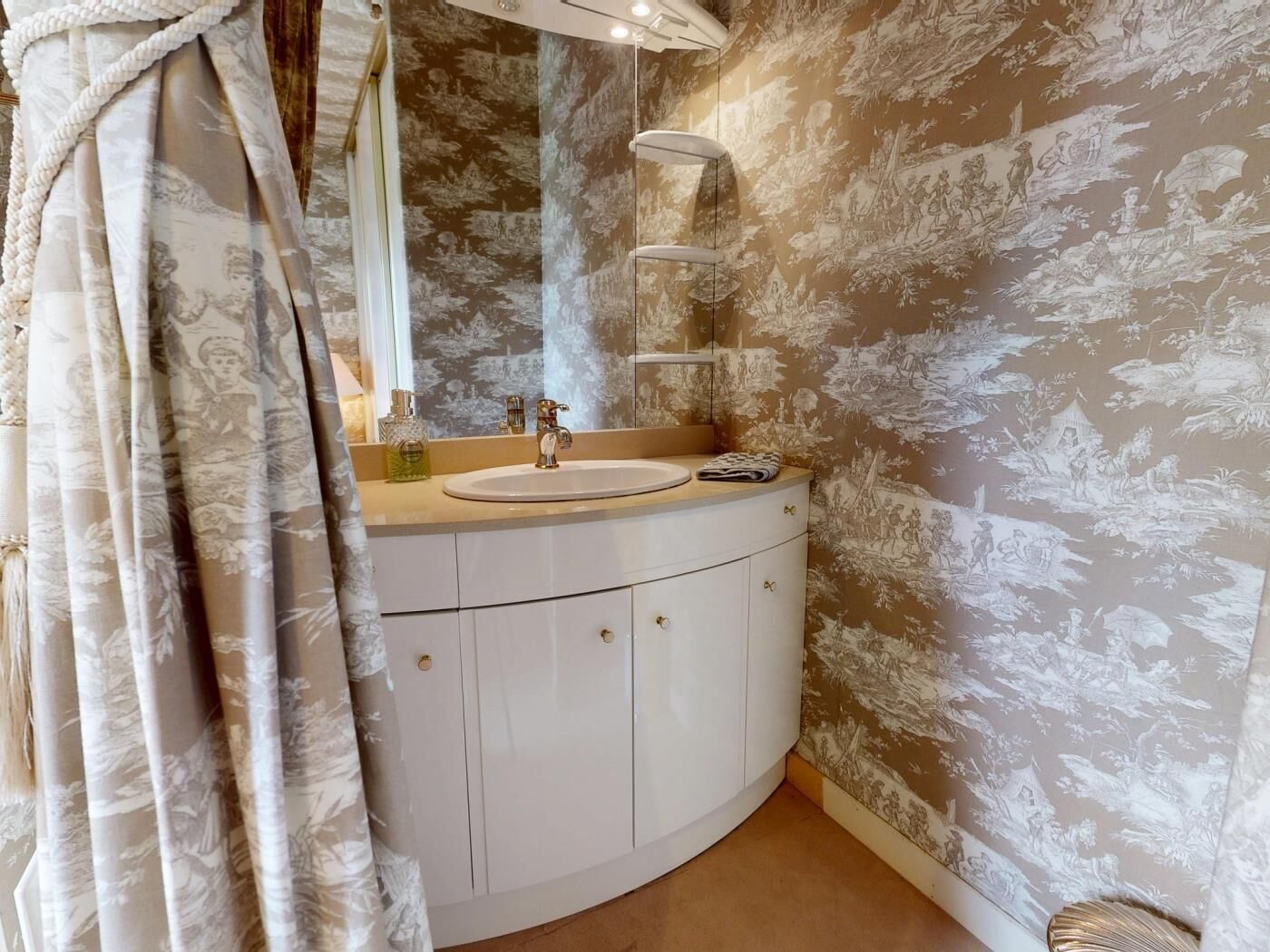 A bathroom with a white vanity, a round sink, a mirror, and a shower curtain.