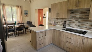 Une cuisine moderne avec des meubles en bois, un plan de travail blanc et une cuisinière intégrée.