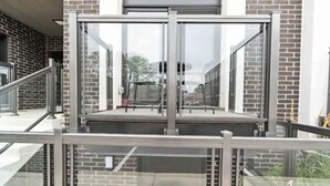 A modern building with a glass elevator, metal railings, and a brick facade. - Luxury New Condo By Niagara Falls (Niagara Falls)