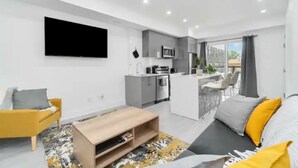 A modern apartment with a living room, kitchen, and balcony. - Luxury New Condo By Niagara Falls (Niagara Falls)