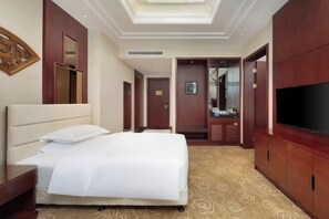 A hotel room with a large bed, a flat-screen TV, a mirror, and a wardrobe. - Duyun YunDong Guizhou Hotel (Duyun)
