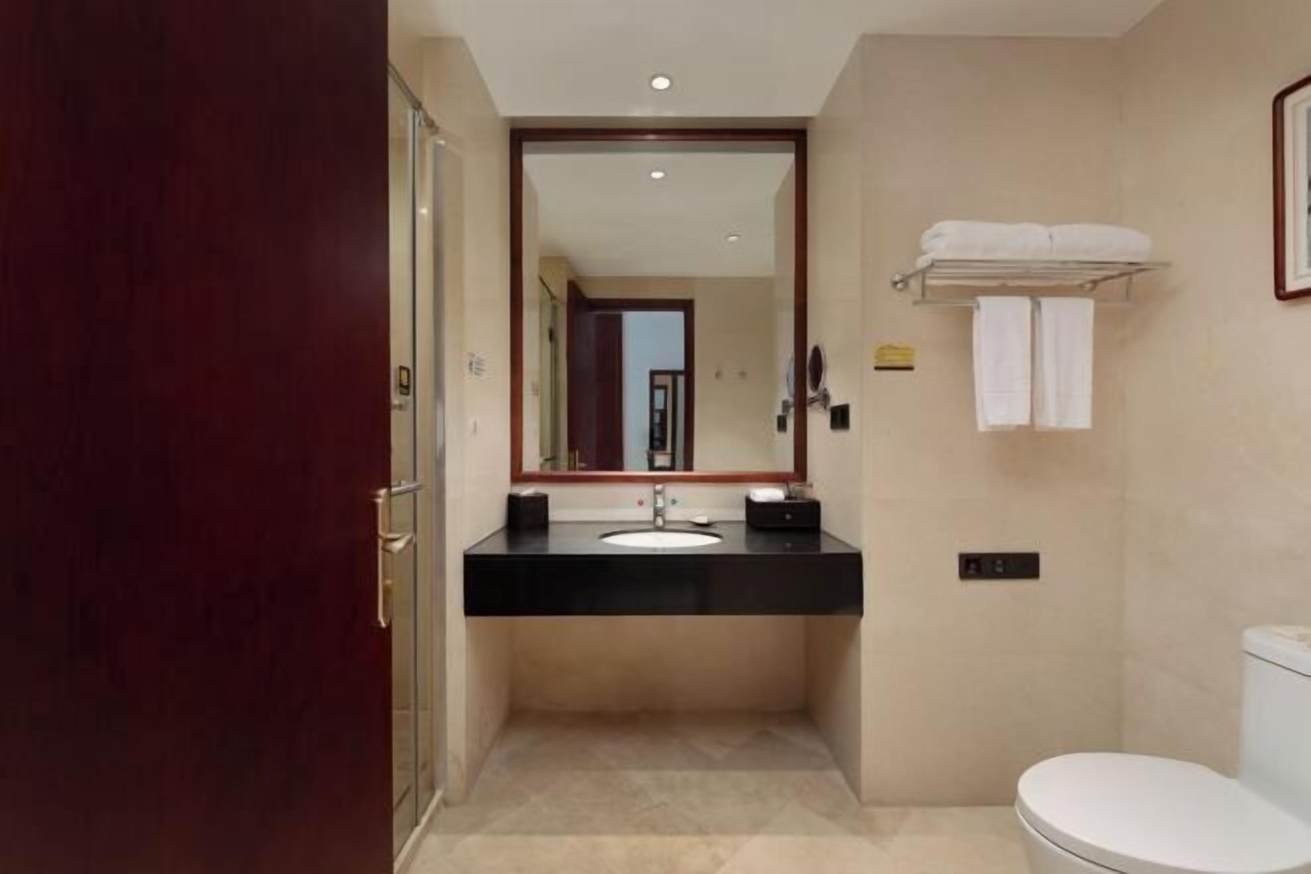 Ein Badezimmer mit Waschbecken, Spiegel und Toilette.