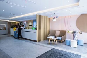 A hotel reception area with a reception desk, seating area, and a plant. - Homeinn Hotel·neo(Xiushanmen Square Store, Qiupu West Road) (Chizhou)